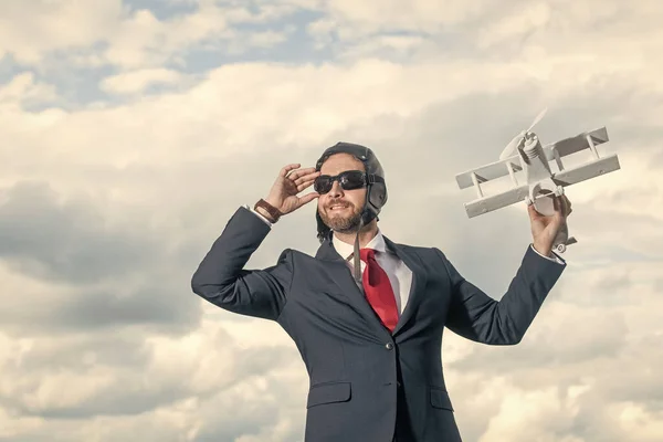 businessman smile in suit and pilot hat launch plane toy.