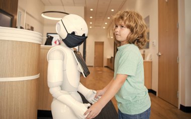 Oğlan robotla yenilikçi teknoloji ve iletişim gibi etkileşim içinde..