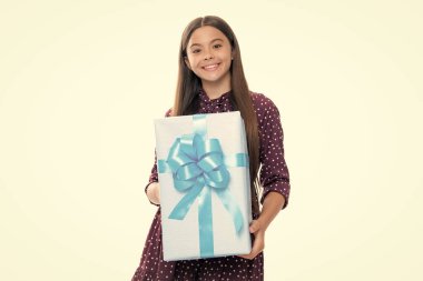 Stüdyonun arka planında hediye kutusu olan çocuk. Çocukların doğum günü hediyesi. Mutlu gülümseyen genç kızın portresi.