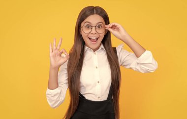 Okul üniformalı, gözlüklü, vizyon koruması için gözlüklü, şaşırmış bir çocuk..