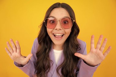 Şaşırmış genç kız. Şok olmuş genç bir çocuk sarı arka planda şaşkın şaşkın bakıyor, hayret. Heyecanlı bir ifade, neşeli ve mutlu.