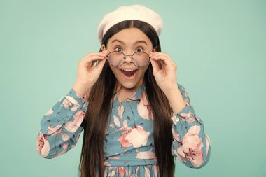 Gözlüklü ergen çocuk portresi. Göz testindeki çocuk. Gözlük tutan ve kameraya bakan bir kız. Görüş, okul çocukları için görme ölçüsü