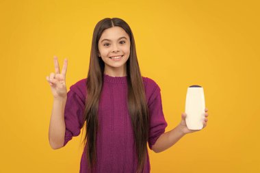 Şampuan kremi ve duş jeli olan genç bir kız. Genç kızın uzun saçı. Kozmetik ürünler, şampuan şişesi. Saçlarını şampuanlıyordum.