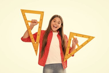 Çocuk matematik okuyor. Boyutunu ölçün. Trigonometri kırtasiyesi. Ölçme ve ölçme. Çocuk eğitimi. Matematik. Gülen genç kız üçgen cetvel tutuyor. Okula dönüyorum. Cebir ve geometri.