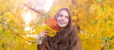 Autumn fall woman banner with copy space. happy girl with school bag near autumn colorful leaves on rowanberry tree, nature