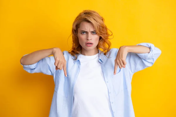 Woman point at copy space, showing copyspace pointing down. Promo, girl showing advertisement content gesture, pointing with hand recommend product. Isolated background