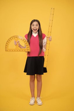 Matematiğe çalış. Trigonometri kırtasiyesi. Çocuk matematik okuyor. Çocuk eğitimi. açı derecesi ölçülüyor. Ölçüm. İletki cetvelli genç kız şaşırdı. Okula geri dön..