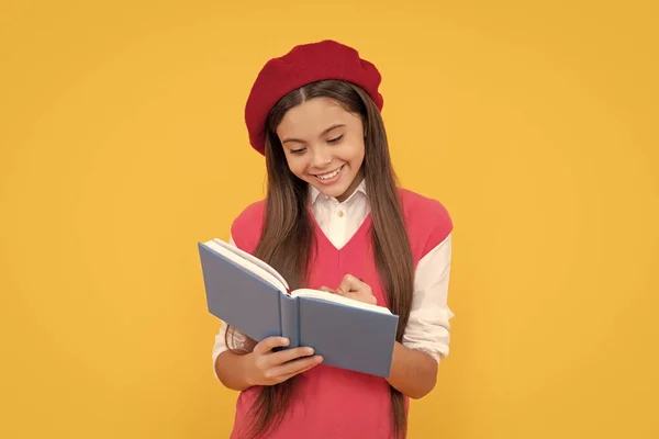 happy teen school girl in french beret making notes in planner notepad or notebook, writing.