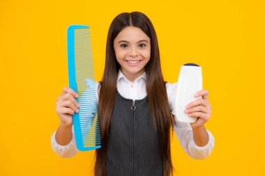 Teenager child girl showing bottle shampoo conditioners or shower gel. Hair cosmetic product. Bottle for advertising mock up copy space