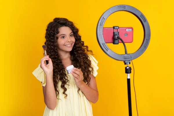 Young blogger child recording video for blog. Teen girl speaking in front of camera for vlog. Teenager working as blogger, recording video tutorial for blog. Happy teenager, positive and smiling