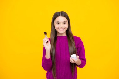 Kids make up products. Makeup teen child artist apply face powder with make up brush. Beauty, and cosmetics for teenagers