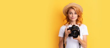 smiling redhead woman photographer with camera in straw hat making photo, photography. Woman isolated face portrait, banner with mock up copy space