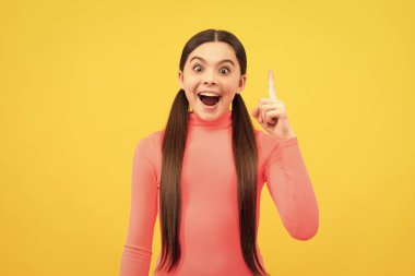 İlham ve şaşkınlık. Harika bir fikri olan ilham verici bir çocuk. Güzellik ve moda. Kadın manken. Sarı arka planda güzel bir genç kız. Mutlu çocuk portresi. pozitif duyguları ifade et.