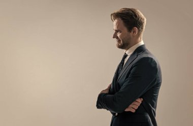 Kendine güvenen bir patron olmak. Güvenilir CEO gri arka plan. Profesyonel bir adam kollarını kendine güvenle kavuşturur. Formalite icabı mutlu iş adamı, kenara çekil, boşluğu kopyala.