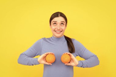 diyet ve cilt güzelliği. Portakallı turunçgil meyveli mutlu kız. Vitamin ve diyet. Sağlıklı yiyecekleri tutan kadın. Doğal organik greyfurttan sağlık.