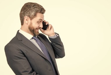 Şaşırmış iş adamı beyaz fotokopi odasında izole edilmiş cep telefonuyla konuşuyor..