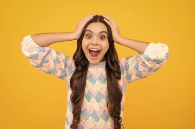 Heyecanlı bir yüz. Sarı arka planda ağzı açık hayret bir çocuk, sürpriz.