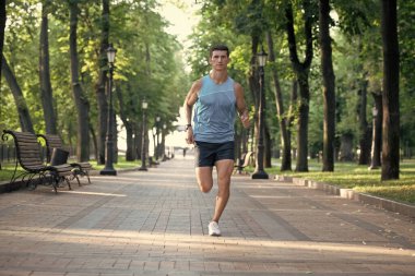 Atletik koşucu spor kıyafetleri içinde koşuyor..
