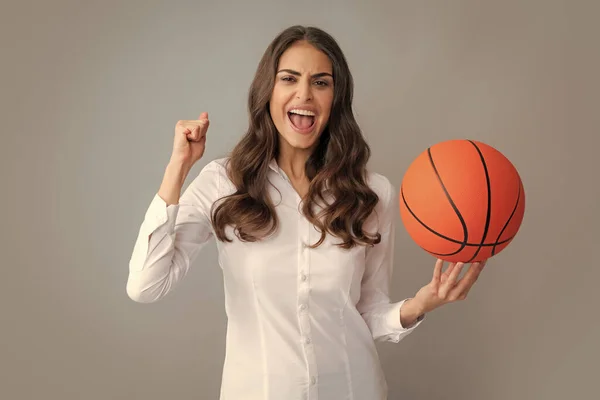 幸せな女性は 灰色の背景に隔離されたバスケットボールボールを保持 — ストック写真