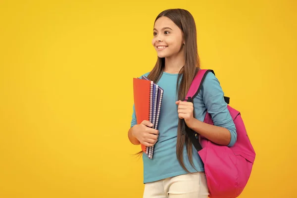 学校に戻る 10代の女子学生は本とコピーブックを持っています学ぶ準備ができて 孤立した黄色のスタジオの背景に学校の子供 幸せなティーンエイジャーの肖像画 笑顔の女の子 — ストック写真