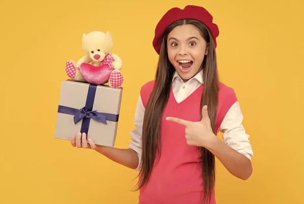 teenage beauty go shopping. tween and youth. purchase a gift. happy french teen girl pointing finger present box. childhood happiness. boxing day. kid in beret with toy. amazed child has birthday.