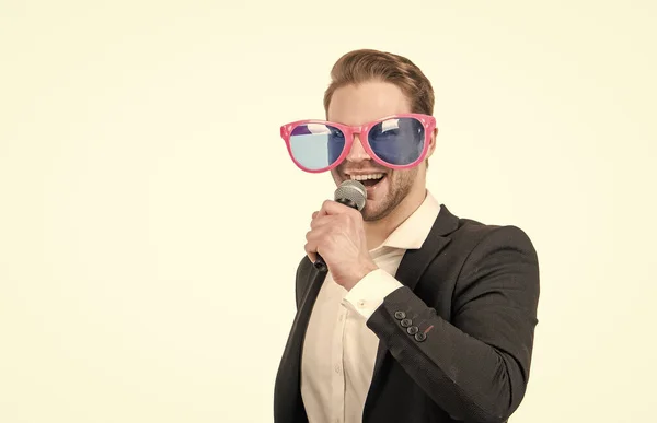 Sing as you can. Happy businessman sing song. Professional man in funny sunglasses with microphone. Karaoke. We can help you with your singing, copy space.