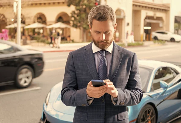 car rent dealer chatting on phone outdoor.