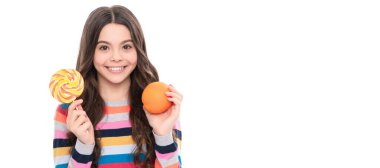 Portakal meyveli ve lolipoplu renkli kazaklı mutlu çocuk beyaz ve sağlıklı bir çocuklukta izole edilmiş. Portakallı, yatay posterli çocuk portresi. Kopyalama alanı olan başlık