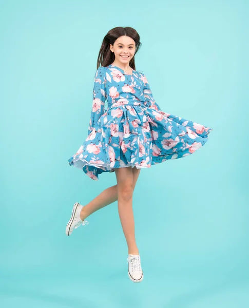 Amazed expression, cheerful and glad. Full length little overjoyed teen girl 12, 13, 14 year old jump and run isolated on blue background studio. Excited teenager, amazed and cheerful emotions
