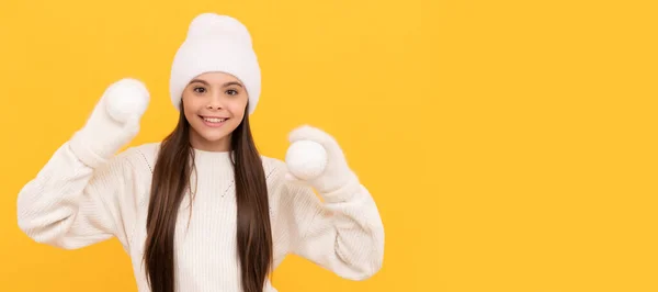 冬の帽子と手袋の幸せな子供は黄色の背景に雪玉を保持します クリスマスの子供の女の子のバナー スタジオの子供の冬の肖像画とともにコピースペース — ストック写真