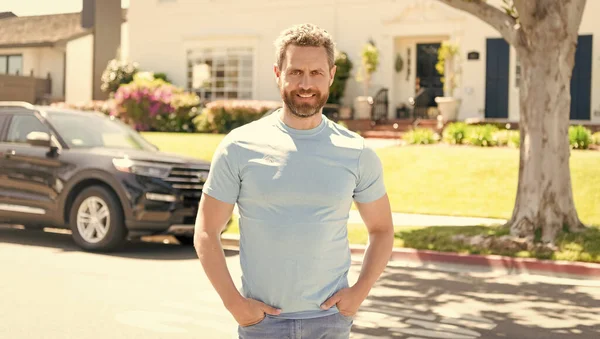 happy confident man stand at new house and car.