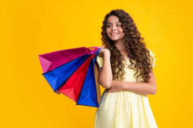 Sale and shopping concept. Teen girl holding shopping bags, isolated on studio background. Happy teenager portrait. Smiling girl