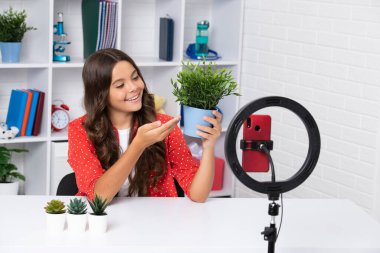 Video bloğu için kameranın önünde konuşan genç kız. Blogcu olarak çalışan bir genç, video blogu kaydediyor. Mutlu kız yüzü, pozitif ve gülümseyen duygular
