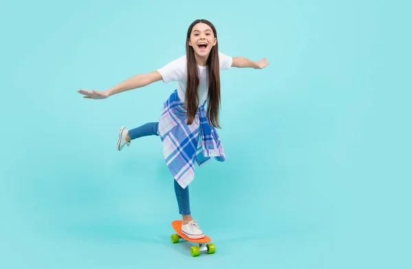 Teen school girl with skateboard on studio isolated background. Schoolgirl spring trend, urban teenager style. Happy teenager, positive and smiling emotions of teen girl