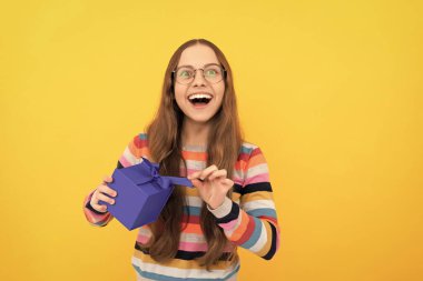 Gözlüklü mutlu genç kız doğum günü hediyesi kutusunu açıyor, mutlu yıllar..