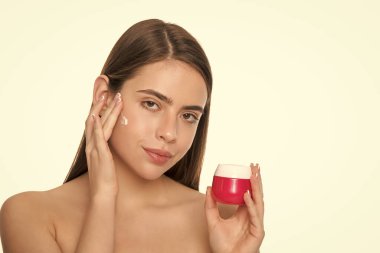 Bayan kozmetik ürünü sunuyorum. Yüz kremi süren bir kadın. Genç kız saç maskesi takıyor. Cilt kremi olan bayan. Günlük alışkanlık ve kişisel bakım. Cilt güzelliği. Güzellik kozmetiği. Temizleme fırçası.