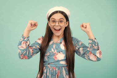 Kazanan jest yapan genç çocuğun stüdyo portresi. Cocuk sevinci, evet zafer sampiyonu jesti, yumruk pompasi. Heyecanlı genç, şaşkın ve neşeli duygular.