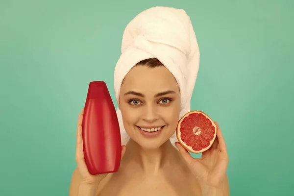 Blij Vrouw Handdoek Met Grapefruit Shampoo Fles Blauwe Achtergrond — Stockfoto