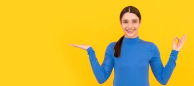 Reklam. Neşeli kadın fotokopi alanında ürün sunuyor. Güzellik ve moda. İzole edilmiş yüz portresi, afiş başlığı posteri ve kopyalanmış kopya alanı