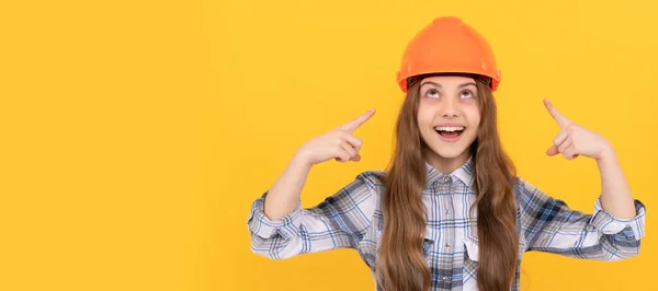 ヘルメットの10代の女の子を構築 幸せな10代の女の子チェックされたシャツのヘルメットに指を指して 保護します ハード帽子水平ポスターデザインの子供 バナーヘッダー コピースペース — ストック写真