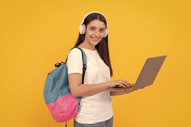 Kablosuz kulaklıkla giyin. Modern eğitim. İletişim teknolojisi. Sırt çantalı kadın laptopta sohbet ediyor. İnternetten al. Okula dönüyorum. Etkileyici bloglar. Kulaklıklı mutlu kız..