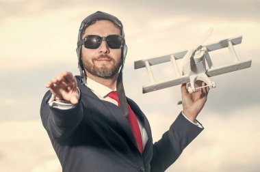 Takım elbiseli iş adamı ve pilot şapkalı uçak oyuncağı. fırsat.