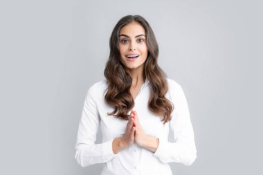 Pretty woman dressed casually in shirt looking with satisfaction. Studio shot of beautiful woman isolated against gray background. Excited female model