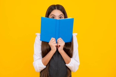 Kopya kitabı olan liseli kız izole edilmiş arka planda poz veriyor. Edebiyat dersi, ilkokul. Entelektüel çocuk okuyucu