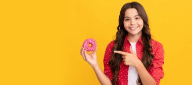 Mutlu çocuk, tatlı jöleli donutu işaret ediyor, yemek yiyor..