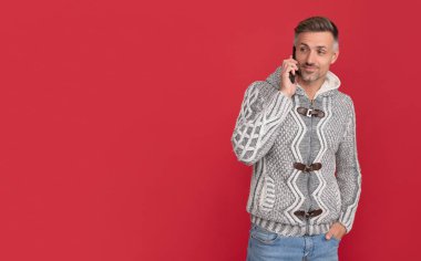 Kazaklı gülümseyen adam telefonda kırmızı arka planda konuşuyor, modern hayat..