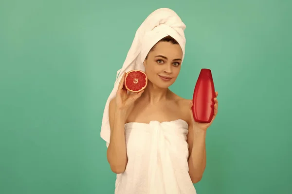 Cheerful Young Woman Towel Grapefruit Shampoo Bottle Blue Background — Stockfoto
