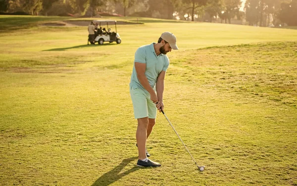 standing golfer in cap with golf club, golf swing.