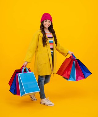 Alışveriş torbaları olan şık bir genç kız. Alım satım yapan çocuk. Moda tarzı bir çocuk. Mutlu ergen, pozitif ve gülümseyen genç kız duyguları