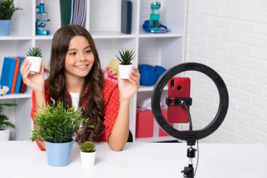 Gençler çevrimiçi medya videosu kaydediyor. Genç kız çevrimiçi yayın yapıyor ve cep telefonu uygulaması ile sosyal medya içeriğini paylaşıyor. Mutlu kız yüzü, pozitif ve gülümseyen duygular